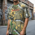 Person wearing a camouflage t-shirt with a brand logo in an urban setting